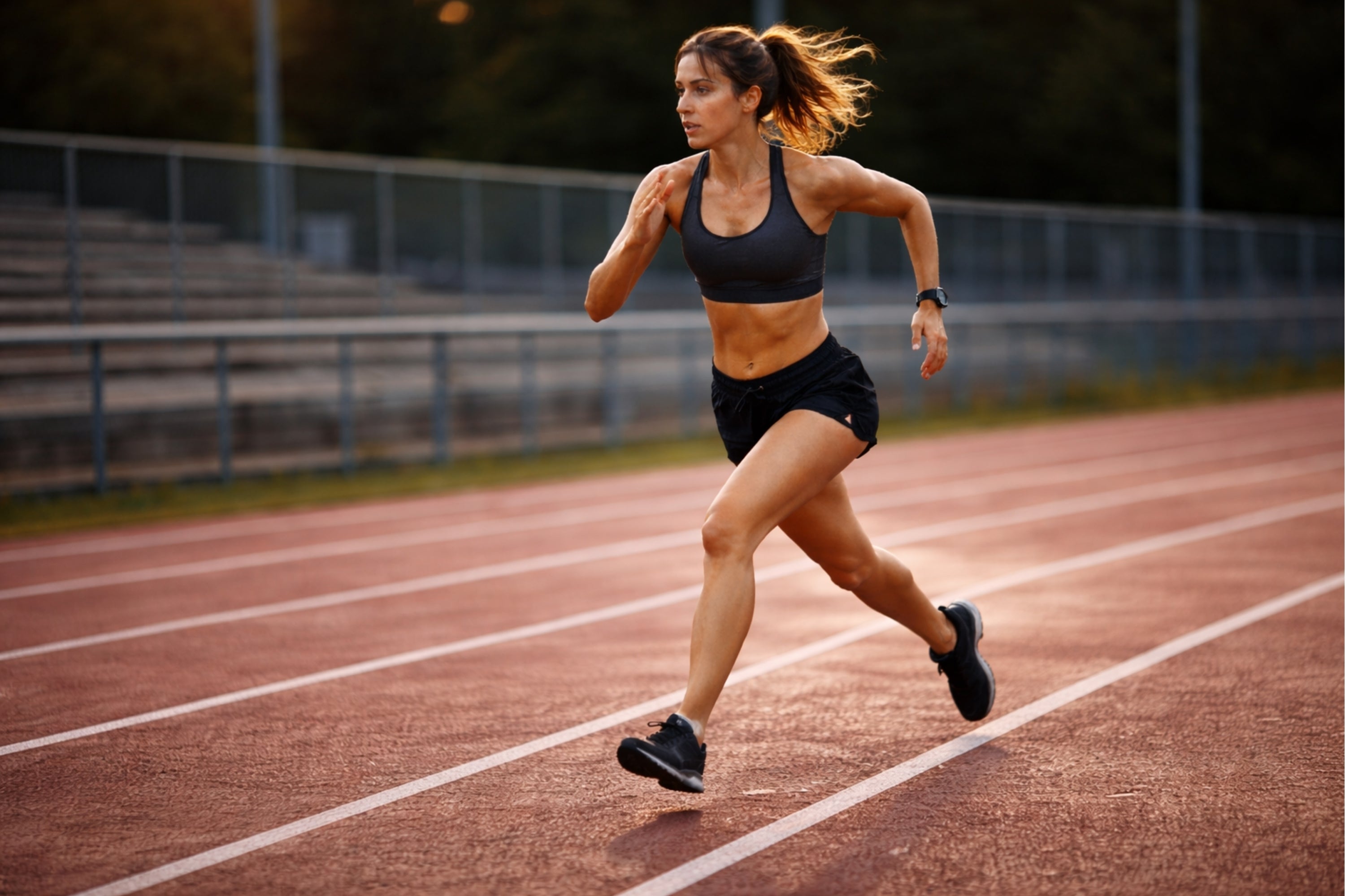 Woman running on a track in an outdoor setting